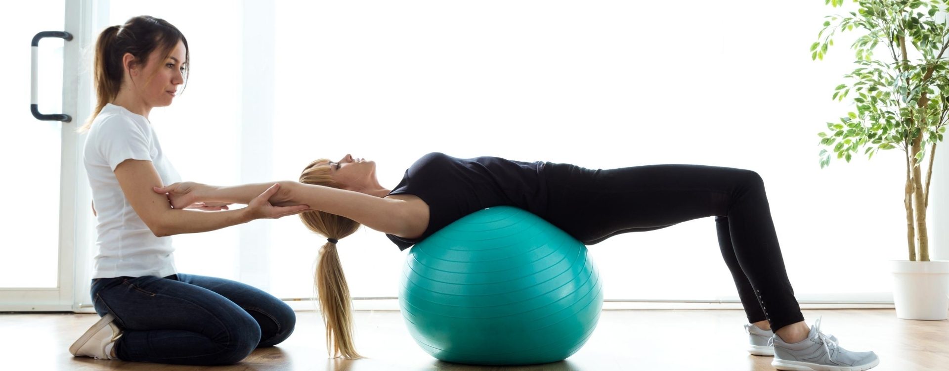 Physiotherapist supervising a strengthening exercise on a gym ball during rehabilitation at PREP Physio