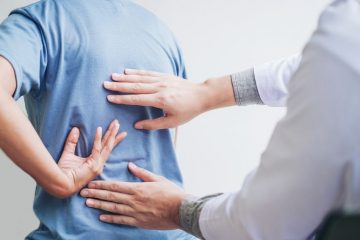 Chartered physiotherapist assessing a patient with lower back pain